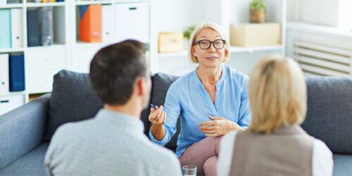 Experienced professional speaking with two individuals during a counseling session, representing life sciences executive search and staffing