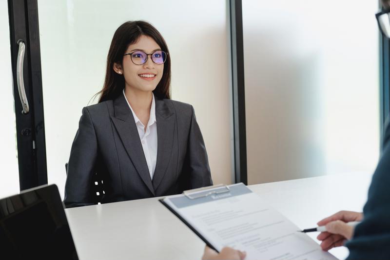A woman sitting at a table at a job interview.