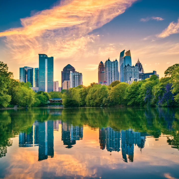 Sunset view of the Atlanta skyline reflected in a calm lake at Piedmont Park, representing top-tier temp staffing and consulting in Atlanta.
