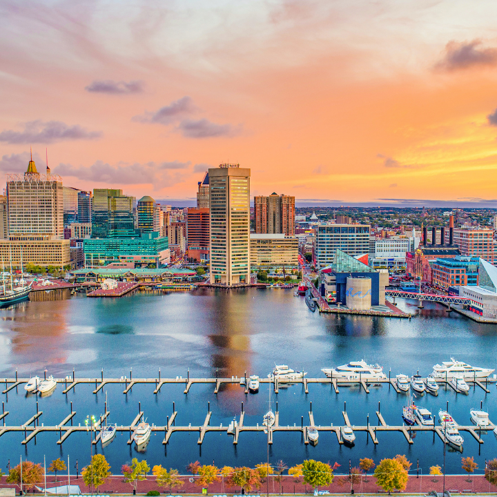 Sunset view of the Baltimore, Maryland skyline with glowing city lights and waterfront, highlighting the city's role as a hub for staffing agency services.