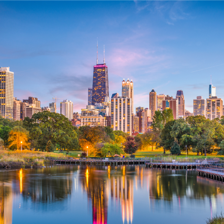 Evening skyline view from Lincoln Park in North Chicago, featuring downtown skyscrapers, green space, and reflective water—highlighting the area's connection to professional temp staffing and consulting services.